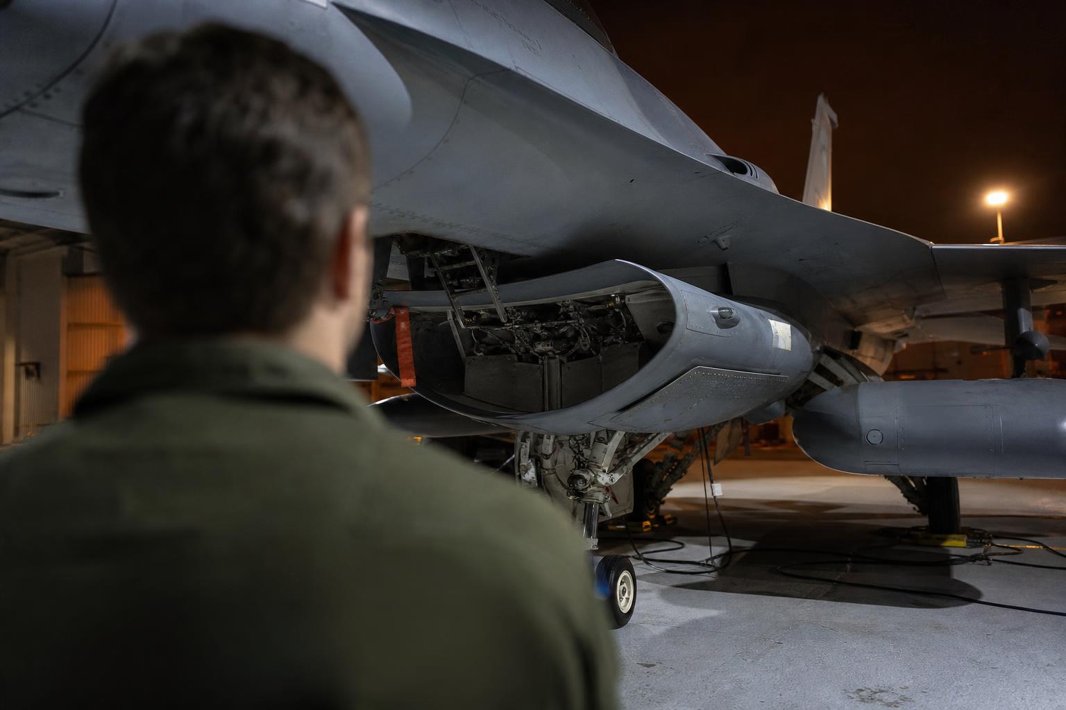 Maintainer using a ruggedized tablet in a hangar at night